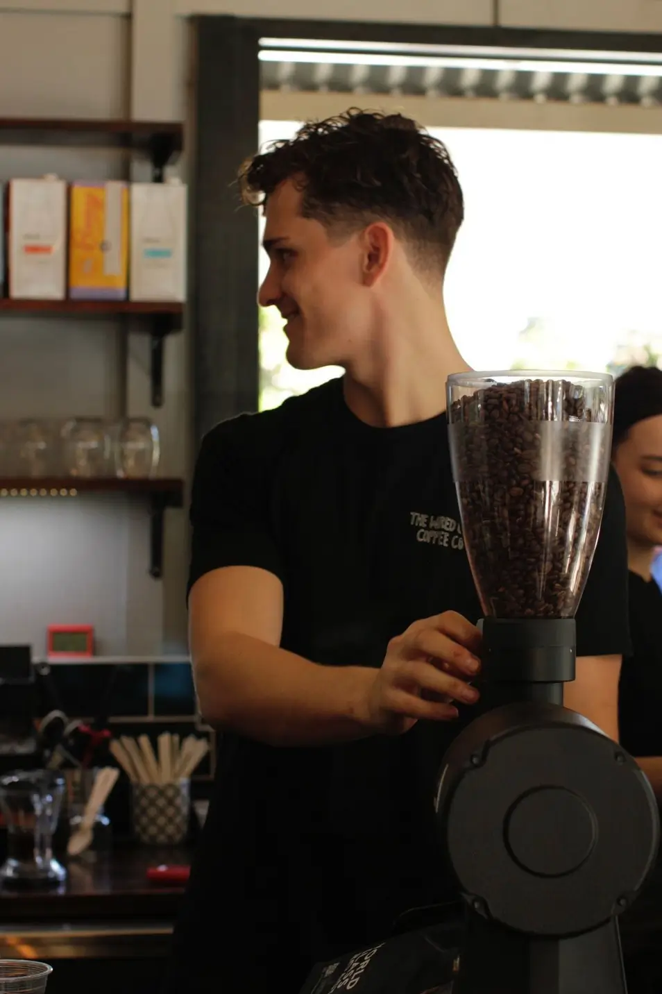 Staff member grinding coffee beans